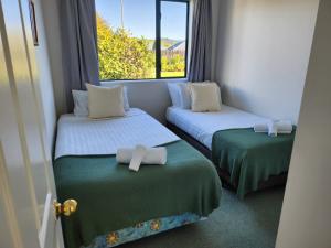 two twin beds in a room with a window at Mountainview in Kaikoura