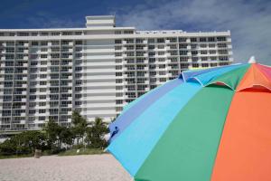 a colorful umbrella on the beach next to a large building at Pavilion - Great ocean view -Miami Beach in Miami Beach