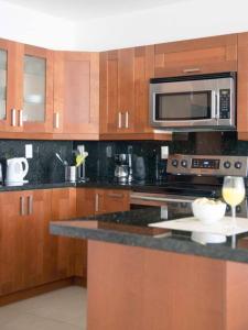 cocina con armarios de madera, microondas y encimera en Miami on the Beach-Great ocean view -Miami Beach, en Miami Beach