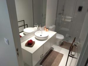- une salle de bains blanche avec deux lavabos et une douche dans l'établissement Cais das Pedras Pátio Apartment, à Porto