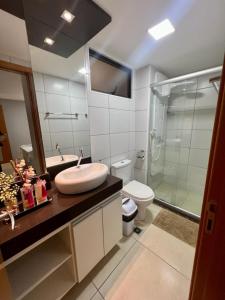 uma casa de banho com um lavatório, um chuveiro e um WC. em Apartamento a beira-mar com piscina em Cabedelo