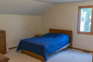 Au Gres的住宿－Lakeview & Wildlife，一间卧室设有蓝色的床和窗户。