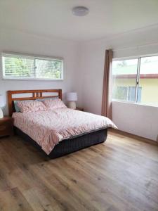 a bedroom with a bed and a wooden floor at Spacious, Modern & Central in Atherton