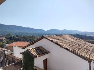 una casa bianca con tetto con montagne sullo sfondo di Casa Bela Vista a Tiradentes