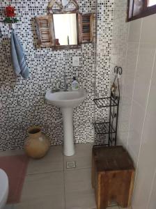 un bagno con un lavandino, uno specchio e uno sgabello di Casa Bela Vista a Tiradentes