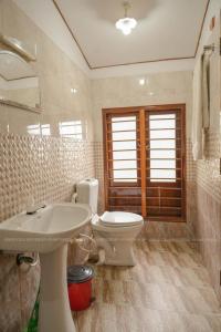 uma casa de banho com um lavatório, um WC e um espelho. em Grand Villa Houseboat em Kumarakom