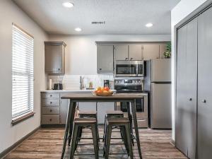 a kitchen with a table and two stools in it at Freestanding 2 Bedroom Cabins 