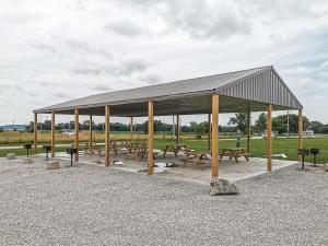 a pavilion with benches and picnic tables in a park at Freestanding 2 Bedroom Cabins 