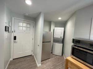 uma pequena cozinha com um frigorífico e uma porta em Sonsak - Unit 5 em Charlottesville
