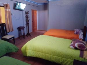 um quarto com 2 camas e uma televisão de ecrã plano em Wayky's Club and Hostal em Copacabana