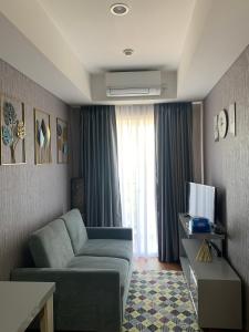 sala de estar con sofá y TV en Apartermen Skylouge Makassar en Manda