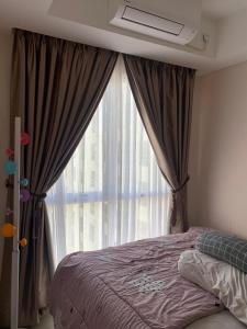 a bedroom with a bed and a large window at Apartermen Skylouge Makassar in Manda