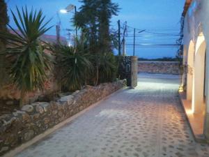 een loopbrug naar een huis met een stenen muur bij Villas del Sol in Bernal