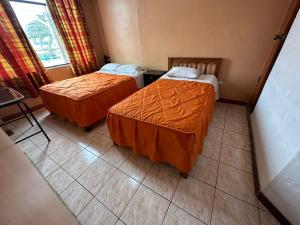 a hotel room with two beds and a window at HOSPEDAJE CALLAO in Tacna