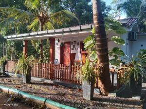 マータラにあるLovers Green Villaの塀と椰子の木のある家