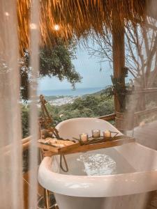 a bath tub in front of a window with candles at Greenheart garden View Camp phuket in Kata Beach