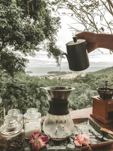 a person holding a cup in a blender on a table at Greenheart garden View Camp phuket in Kata Beach