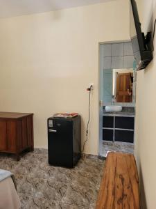 a room with a refrigerator in the corner of a room at Suítes Boa Viagem in Pirenópolis