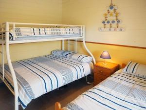 1 dormitorio con 2 literas y lámpara en Vertigo...great family holiday house, en Blairgowrie