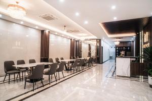 Milan Hotel Ninh Bình في نينه بينه: مطعم فيه طاولات وكراسي في لوبي