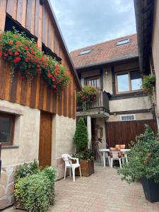 budynek z patio ze stołami, krzesłami i kwiatami w obiekcie Appartments Rue Des Châteaux w mieście Ottrott