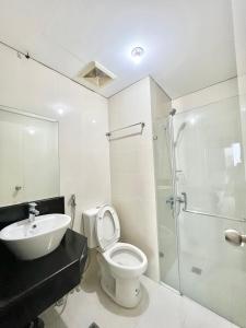 uma casa de banho com um WC, um lavatório e um chuveiro em Kiel 4-Star Condo Hotel Near NAIA Manila Airport Terminal em Manila