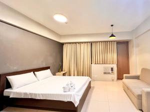um quarto com uma cama grande e um sofá em Kiel 4-Star Condo Hotel Near NAIA Manila Airport Terminal em Manila