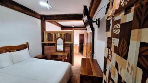 a bedroom with a bed and a table and a mirror at Hotel Colonial Taxco in Taxco de Alarcón