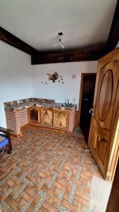 una camera con pavimento in mattoni e porta in legno di Hotel Colonial Taxco a Taxco de Alarcón