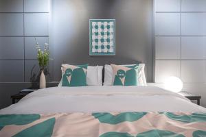 - une chambre dotée d'un grand lit avec des oreillers verts et blancs dans l'établissement BY THS Valentine Hotel Incheon, à Siheung