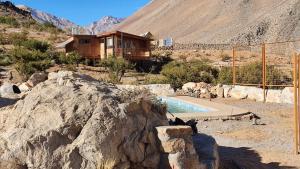 a house in the middle of a mountain with a pool at Samay Lodge in Cochiguaz