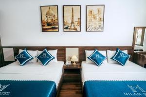 Cette chambre comprend 2 lits avec des oreillers bleus et blancs. dans l'établissement Milan Hotel Ninh Bình, à Ninh Binh
