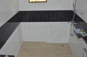 uma casa de banho com uma parede a preto e branco em Amazon Cabanas em Tissamaharama