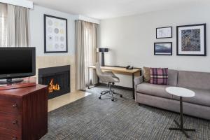 a hotel room with a couch and a fireplace at Trellis Durham RTP in Durham