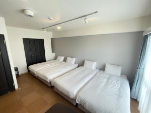 Letto o letti in una camera di BiBi Hotel Cosmos Shintoshin