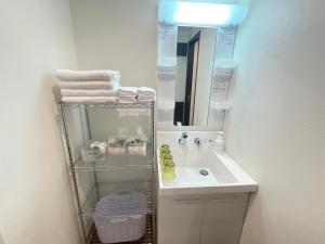 un bagno con un lavandino bianco e uno specchio di BiBi Hotel Cosmos Shintoshin a Naha Altre 35 foto
