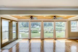 an empty living room with large windows at NEW! Lake Winnebago Waterfront Retreat in Oshkosh