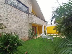 einen Hinterhof mit einer Bank im Gras in der Unterkunft Casa Central Art Decor com Piscina e BBQ in Foz do Iguaçu