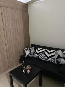 a living room with a black couch and a table at Shore 2 Tower 2 Staycation in Manila