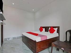 a bedroom with a bed with red pillows on it at OYO Flagship Moon Light Guest House in Faridabad