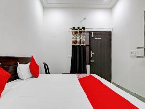 a bedroom with a red and white bed and a door at OYO Flagship Moon Light Guest House in Faridabad