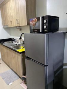 a kitchen with a microwave on top of a refrigerator at Shore 2 Tower 2 Staycation in Manila
