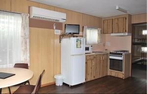 a kitchen with a white refrigerator and a table at Southside Village in Fyshwick