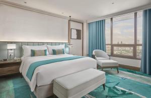 a bedroom with a bed and a chair and a window at Holiday Inn Manila Galleria, an IHG Hotel in Manila