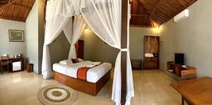 a bedroom with a bed with a canopy at Kampoeng Joglo Ijen in Banyuwangi