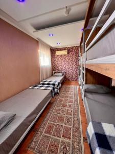 a row of bunk beds in a room with a rug at InJoy hostel in Shymkent