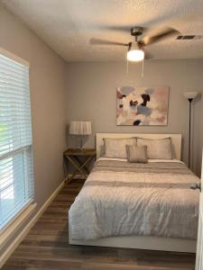 Schlafzimmer mit einem Bett und einem Deckenventilator in der Unterkunft Spacious n Cozy 3 Bedroom // 15 min from Downtown in Houston