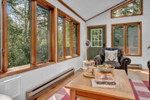 a living room with a table and some windows at Serene & Fun Family Gem ~ Big Bass Lake Community! in Gouldsboro