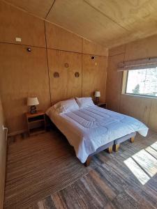 a bedroom with a large bed and a window at Samay Lodge in Cochiguaz