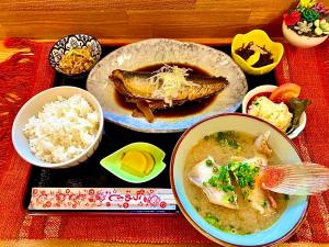 una tavola ricoperta di ciotole di cibo e riso di 海人の宿 口福丸 KoufukuMaru a Yabiku